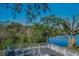 Picturesque water view from the deck, showcasing the tranquil lake and surrounding lush trees creating a serene retreat at 5153 Bay Blvd, Port Richey, FL 34668