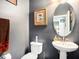 Powder room with oval mirror, pedestal sink, and gray walls at 5714 Colony Glen Rd, Lithia, FL 33547