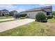 Exterior view of home and yard with concrete driveway and lush grass at 5714 Colony Glen Rd, Lithia, FL 33547