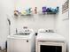 Functional laundry room with washer, dryer, and storage shelves at 5714 Colony Glen Rd, Lithia, FL 33547