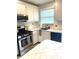 Well-lit kitchen with updated appliances, tile backsplash, and efficient layout for cooking at 5955 30Th S Ave # 108, Gulfport, FL 33707