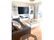 Comfortable living room featuring contemporary furniture, a large entertainment unit, and warm wood flooring at 5955 30Th S Ave # 108, Gulfport, FL 33707