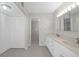 Bright bathroom with dual sinks, white cabinets, tile flooring, and a large closet at 5980 Shore S Blvd # 312, Gulfport, FL 33707