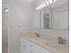 Bathroom featuring dual sinks with marble countertop, large mirror with lighting, and white cabinetry at 5980 Shore S Blvd # 312, Gulfport, FL 33707