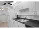 Clean kitchen with white cabinets, black appliances, and tiled flooring at 5980 Shore S Blvd # 312, Gulfport, FL 33707