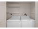 Laundry room with a white washer and dryer, storage shelves and white door at 5980 Shore S Blvd # 312, Gulfport, FL 33707