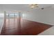 Spacious living room with gleaming hardwood floors, ceiling fans, and expansive windows offering stunning water views at 5980 Shore S Blvd # 312, Gulfport, FL 33707