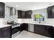 Modern kitchen showcasing dark cabinets, stainless steel appliances, and stylish backsplash at 6070 Denver Ne St, St Petersburg, FL 33703