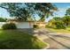 Inviting ranch-style home with a two-car garage and a lush front yard with a long driveway at 631 Luzon Ave, Tampa, FL 33606
