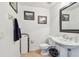 Powder bath with a pedestal sink, framed art, and neutral color palette creates a comfortable and stylish space at 6412 Mayra Shores Ln, Apollo Beach, FL 33572