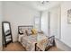 Cozy bedroom features a metal frame bed, soft neutral tones, and a sunny window at 6412 Mayra Shores Ln, Apollo Beach, FL 33572