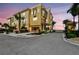 Stunning yellow townhome with a red tile roof, lush tropical landscaping, and a secure gated entrance at 6412 Mayra Shores Ln, Apollo Beach, FL 33572
