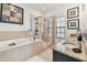This elegant bathroom features granite countertops, a soaking tub and a separate shower at 6412 Mayra Shores Ln, Apollo Beach, FL 33572