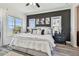 This cozy main bedroom features a black accent wall, gray wood floors and an amazing ocean view at 6412 Mayra Shores Ln, Apollo Beach, FL 33572