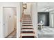 Stylish staircase with wooden treads, black runners and white risers leading to an elegantly designed living room at 6412 Mayra Shores Ln, Apollo Beach, FL 33572