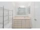 Bathroom with white fixtures including a toilet, sink and cabinet combination, and a stand for storage at 646 Allegheny Dr, Sun City Center, FL 33573