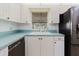 Bright kitchen with white cabinetry, tile flooring, a stainless steel refrigerator, and a window at 646 Allegheny Dr, Sun City Center, FL 33573