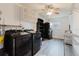 Laundry room with black washer and dryer units, shelves, and a ceiling fan at 646 Allegheny Dr, Sun City Center, FL 33573