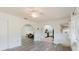 Open living room featuring arched doorways, gray wood-look flooring, and a view into the kitchen at 646 Allegheny Dr, Sun City Center, FL 33573