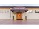 Charming Rollins Theater entrance featuring awning and ornate wooden double doors for an inviting aesthetic at 646 Allegheny Dr, Sun City Center, FL 33573