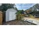 Backyard featuring a storage shed, fire pit, and screened-in porch, perfect for entertaining guests at 6811 S Himes Ave, Tampa, FL 33611