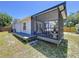 Exterior view of the home's screened-in patio and deck, with a cozy seating area at 6811 S Himes Ave, Tampa, FL 33611