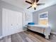 Cozy bedroom featuring wood flooring, ceiling fan, closet and natural light from a window at 6811 S Himes Ave, Tampa, FL 33611