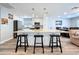 A kitchen island is the center of the space with modern lighting, cabinetry, and bar stool seating at 6811 S Himes Ave, Tampa, FL 33611