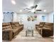 Spacious living room with wood-look floors, ceiling fan, modern artwork, and comfortable, reclining furniture at 6811 S Himes Ave, Tampa, FL 33611