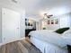 Well-lit main bedroom featuring wood floors and ceiling fan and a view into the main bathroom at 6811 S Himes Ave, Tampa, FL 33611