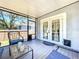 Screened porch with chairs, glass table, and view of fenced backyard at 6811 S Himes Ave, Tampa, FL 33611