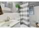 Bathroom featuring a shower with gray and white striped curtain, and white vanity at 7000 14Th N St, St Petersburg, FL 33702