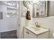 Bathroom with white tiled walls, gray walls, white vanity, and hardwood floors outside the door at 7000 14Th N St, St Petersburg, FL 33702