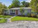 Beautifully landscaped home with red door, lush lawn, and well-maintained front yard exudes curb appeal at 7000 14Th N St, St Petersburg, FL 33702