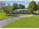 Single-story home with a red door, beautiful landscaping, and a well-maintained front yard at 7000 14Th N St, St Petersburg, FL 33702