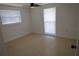 Neutral bedroom with ceiling fan, two windows with blinds, and tile flooring at 7534 Mako Dr, Hudson, FL 34667