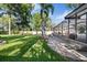 A spacious backyard with green grass and a screened in patio and a beautiful in ground pool at 8020 Sharon Dr, Tampa, FL 33617