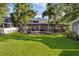 Expansive backyard with lush green grass and features a screened lanai, fire pit, and patio at 8020 Sharon Dr, Tampa, FL 33617