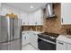 Modern kitchen features white cabinets, stainless steel appliances, and stylish backsplash, perfect for any home chef at 8020 Sharon Dr, Tampa, FL 33617