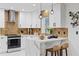 Modern kitchen with white cabinetry, marble countertops, stainless steel appliances, and brick backsplash at 8020 Sharon Dr, Tampa, FL 33617
