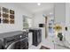 Well-lit laundry room with modern washer and dryer, marble tile floors, and sliding barn door to pool at 8020 Sharon Dr, Tampa, FL 33617