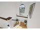 Bright, open staircase with wood steps, white risers, cable railing, and large arched window at 8020 Sharon Dr, Tampa, FL 33617