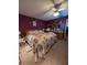 Side view of the bedroom with floral decorations, ceiling fan, and hardwood bed frame at 8119 Oak Trace Way # C, Tampa, FL 33634