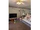 Cozy living room with a large TV, ceiling fan, and carpeted floors at 8119 Oak Trace Way # C, Tampa, FL 33634