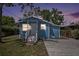 Charming blue single-story home with a well-manicured lawn and a concrete driveway at dusk at 8624 N Semmes St, Tampa, FL 33604