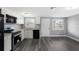 Modern kitchen featuring white cabinets, granite countertops, stainless steel appliances, and stylish flooring at 8624 N Semmes St, Tampa, FL 33604
