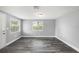 Bright living room with gray walls, wood-look floors, and ample natural light from multiple windows at 8624 N Semmes St, Tampa, FL 33604