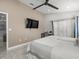 This bedroom features a ceiling fan, neutral palette, desk, and tile flooring at 8702 Pinafore Dr, New Port Richey, FL 34653