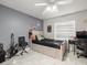 This bedroom has a gray accent wall, a ceiling fan, and is furnished with a desk, chair, and bed at 8702 Pinafore Dr, New Port Richey, FL 34653