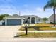 Charming single-story home with a well-manicured lawn, gray exterior, and two-car garage at 8702 Pinafore Dr, New Port Richey, FL 34653